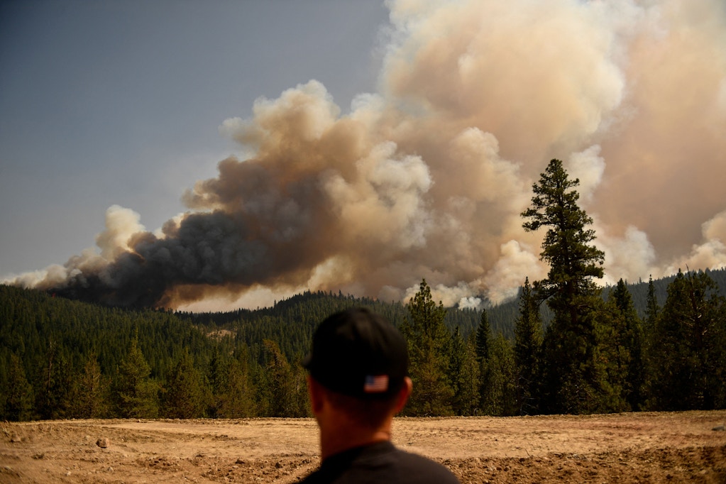 A firefighter looks from Fredonyer Pass as smoke plumes from spot fires rise during the Dixie Fire on August 18, 2021 near Susanville, California. - The wildfire in Northern California continues to grow, burning over 626,000 acres according to CalFire. (Photo by Patrick T. FALLON / AFP) (Photo by PATRICK T. FALLON/AFP via Getty Images)