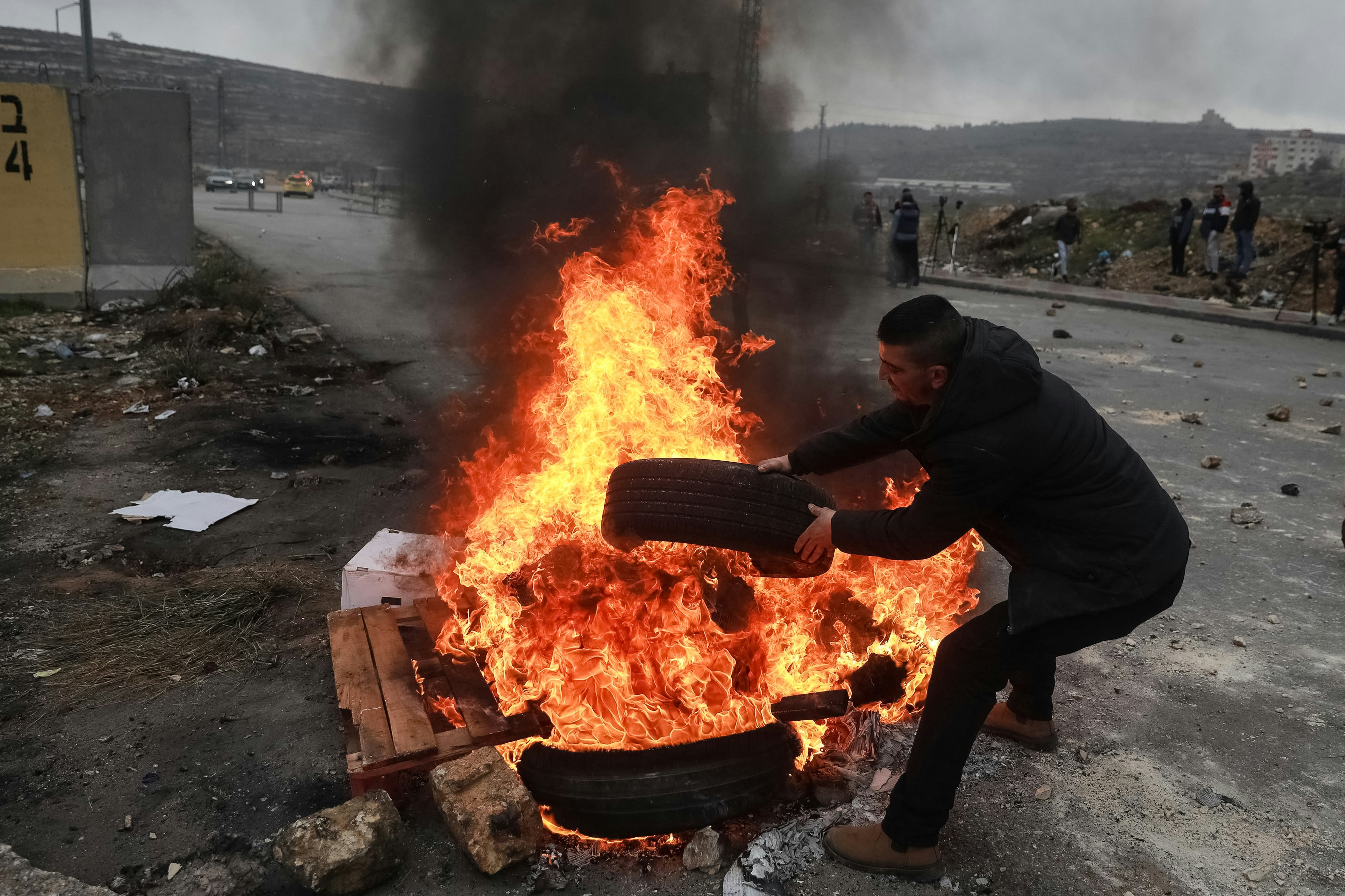 RAMALLAH, CISJORDANIE - 09 FÉVRIER : Un groupe de Palestiniens brûlent des pneus lors d'une manifestation pour montrer la mort de trois Palestiniens nommés Ashraf Mubaslat, Adham Mabrouka et Mohammad Dakhil tués à la suite de tirs des forces israéliennes sur leur véhicule à Naplouse, en février 09/09/2022 à Ramallah, Cisjordanie.  (Photo par Issam Rimawi/Agence Anadolu via Getty Images)