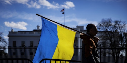 WASHINGTON, DC - FEBRUARY 25: A man with a Ukrainian flag stands on Pennsylvania Avenue in front of the White House as demonstrators gather to protest the Russian invasion on February 25, 2022 in Washington, DC. Russian President Vladimir Putin launched a full-scale invasion of Ukraine on February 24th. (Photo by Samuel Corum/Getty Images)