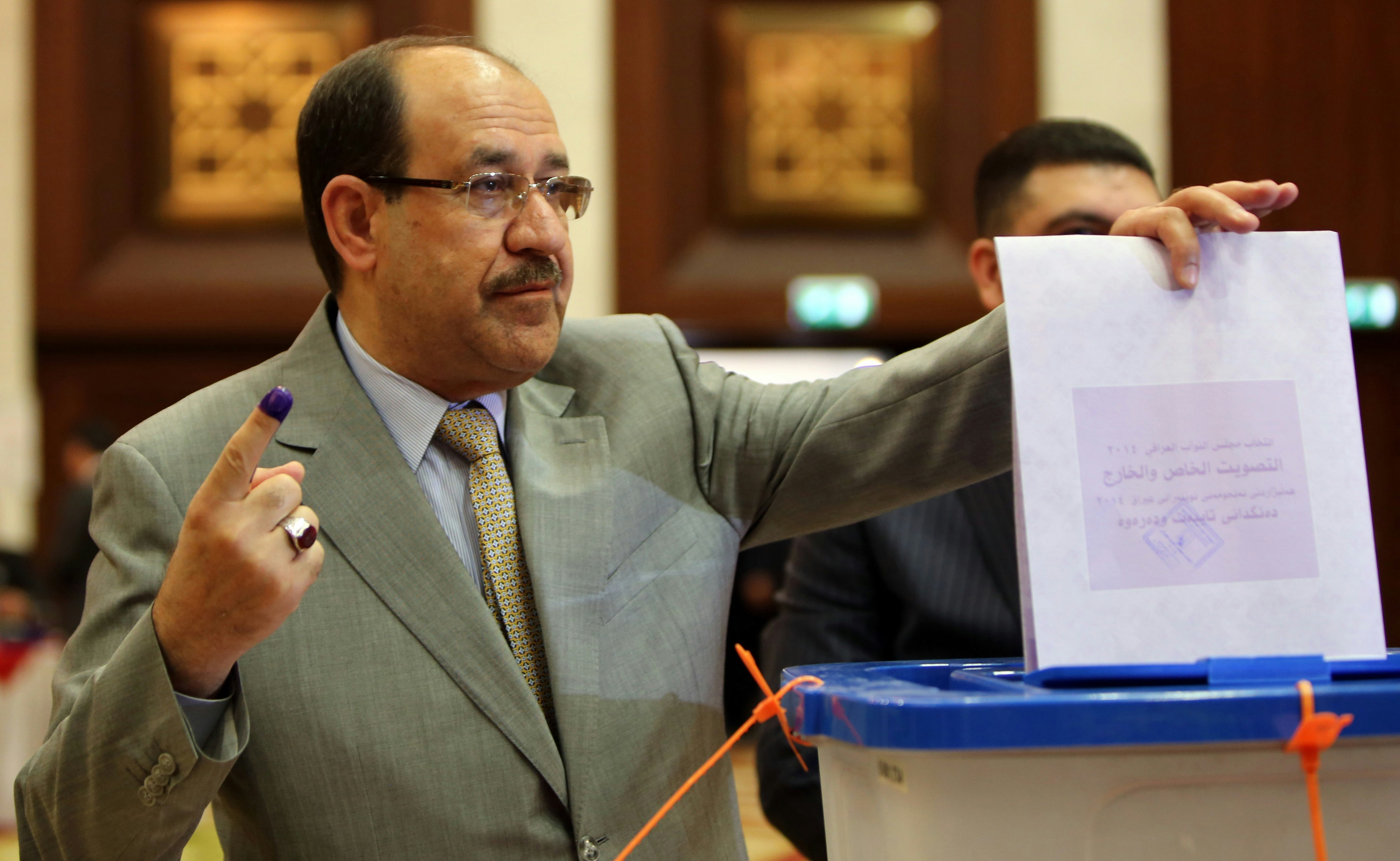 Iraqi Prime Minister Nuri al-Maliki shows his ink-stained finger as he casts his vote in Iraq's first parliamentary election since US troops withdrew at a polling station in Baghdad's Green Zone on April 30, 2014. Iraqis streamed to voting centres nationwide, amid the worst bloodshed in years, as Maliki seeks reelection. AFP PHOTO / ALI AL-SAADI        (Photo credit should read ALI AL-SAADI/AFP via Getty Images)