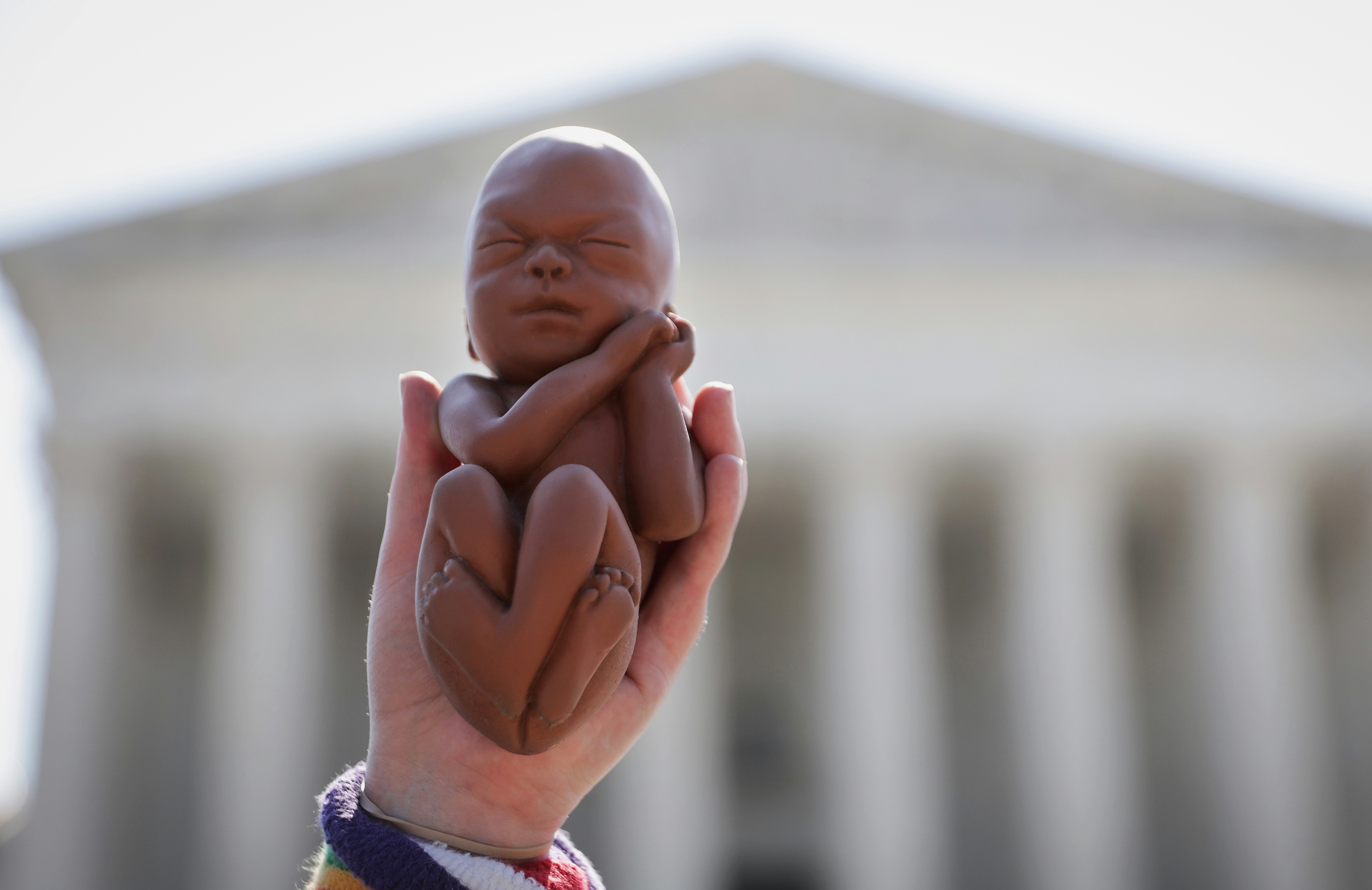 WASHINGTON, DC - JUNE 22:  A pro-life activist holds up a model of a fetus during a protest in front of the U.S. Supreme Court June 22, 2020 in Washington, DC. The Supreme Court is expected to issue a ruling on abortion rights soon. (Photo by Alex Wong/Getty Images)