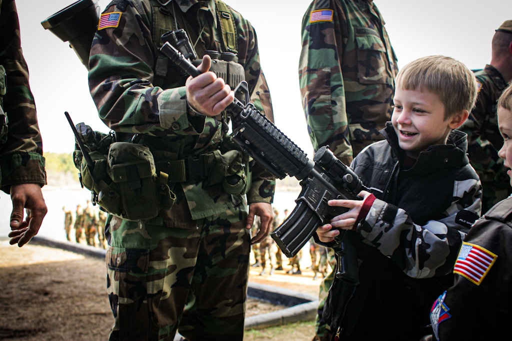 EGLIN AIR FORCE BASE, FLORIDA - JANUARY: A boy attending the graduation ceremony of Rangers completing their military training plays with a machine gun, January 27, 2006 at Eglin Air Force Base in western Florida.  (Photo by Andrew Lichtenstein/Corbis via Getty Images)