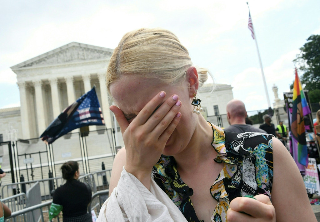 A pro-choice supporter cries outside the US Supreme Court in Washington, DC, on June 24, 2022. - The US Supreme Court on Friday ended the right to abortion in a seismic ruling that shreds half a century of constitutional protections on one of the most divisive and bitterly fought issues in American political life. The conservative-dominated court overturned the landmark 1973 "Roe v Wade" decision that enshrined a woman's right to an abortion and said individual states can permit or restrict the procedure themselves. (Photo by OLIVIER DOULIERY / AFP) (Photo by OLIVIER DOULIERY/AFP via Getty Images)
