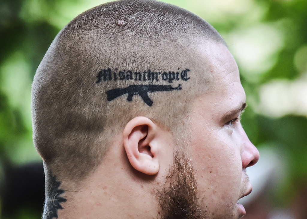 TOPSHOT - A recruit to the Azov far-right Ukrainian volunteer battalion, supports a tattoo on his scalp depicting a Kalashnikov and the word 'Misanthropic' as he takes part in their competition in Kiev, on August 14, 2015 prior leaving to the battle fields of eastern Ukraine. Two people were killed in another round of intense shelling between Western-backed Ukrainian government's forces and pro-Russian fighters in the separatist east, officials from both sides said. Ukraine's military spokesman Andriy Lysenko said one soldier was killed and six wounded in the past 24 hours of fighting across the mostly Russian-speaking war zone. AFP PHOTO/ SERGEI SUPINSKY (Photo by Sergei SUPINSKY / AFP) (Photo by SERGEI SUPINSKY/AFP via Getty Images)