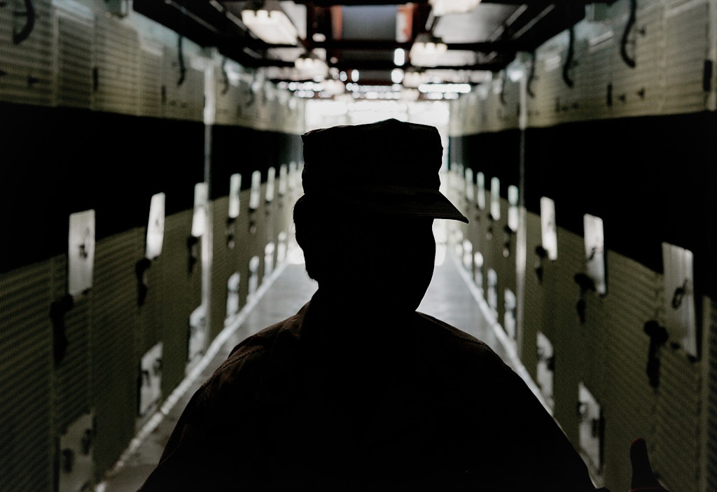GUANTANAMO BAY, CUBA - MAY 09:  (IMAGE REVIEWED BY U.S. MILITARY PRIOR TO TRANSMISSION)  A Member of the U.S. Military is silhouetted while standing inside of the cell block inside of Camp 2 at Camp Delta May 9, 2006 in Guantanamo Bay, Cuba. Camp Delta was first occupied on April 28, 2002, when 300 detainees previously held at Camp X-Ray were transferred to Camp Delta. The rest of the detainees were moved on April 29. Camp X-Ray closed down on that same day.  (Photo by Mark Wilson/Getty Images)