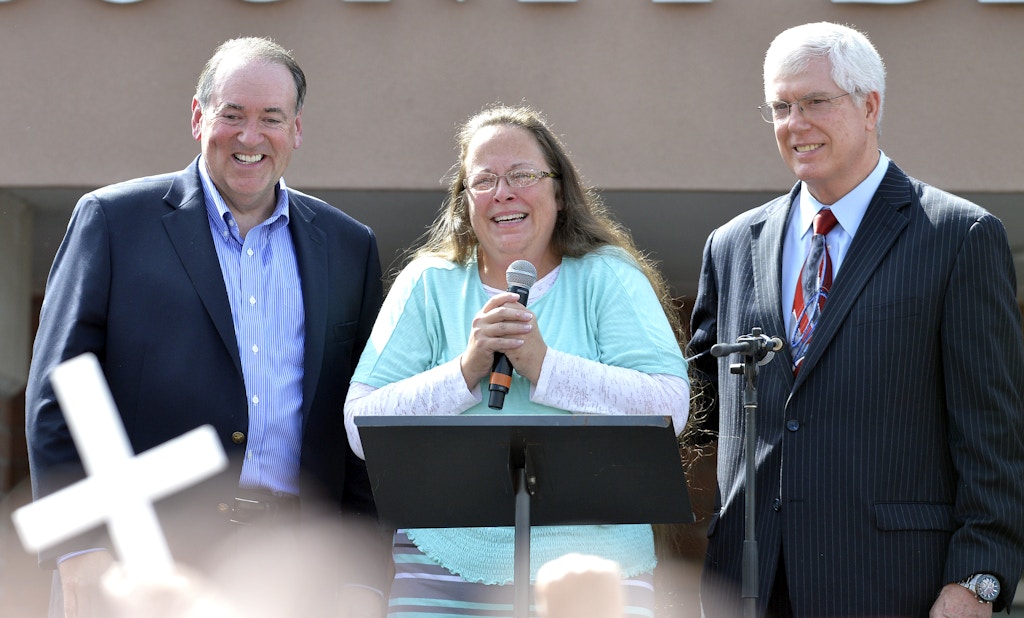 Rowan County Clerk Kim Davis, center with Republican presidential candidate Mike Huckabee, left, and attorney Mat Staver, right, founder of the Liberty Counsel, the Christian law firm representing Davis, at her side, greets the crowd after being released from the Carter County Detention Center, Tuesday, Sept. 8, 2015, in Grayson, Ky. Davis, the Kentucky county clerk who was jailed for refusing to issue marriage licenses to gay couples, was released Tuesday after five days behind bars.   (AP Photo/Timothy D. Easley)
