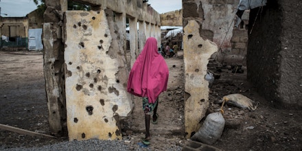 TOPSHOT - A girl walks through the site where the Nigerian Air Force (NAF) mistakenly bombed the Rann Internally-Displaced Peoples (IDP) camp in northeastern Nigeria near the Cameroonian border on July 29, 2017.On January 17, 2017 the Rann Internally-Displaced Persons (IDP) camp was bombed by the Nigerian Air Force (NAF), injuring hundreds of people, killing dozens of civilians and at least six humanitarian workers, in the mistaken belief that the large congregation of people was a Boko Haram militant gathering. / AFP PHOTO / STEFAN HEUNIS (Photo credit should read STEFAN HEUNIS/AFP via Getty Images)