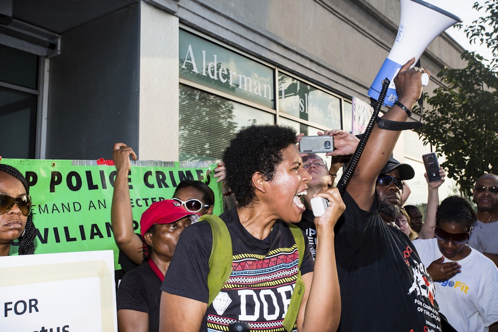 People partake in a rally and march organized by The Chicago Alliance Against Racism and Political Repression, in the South Shore neighborhood near the site where Harith Augustus was shot and killed by Chicago police, Monday, July 16, 2018. (James Foster/Chicago Sun-Times via AP)