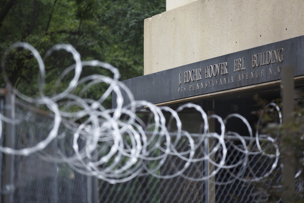 The FBI Headquarters in Washington, D.C. is seen beyond barbed wire fencing surrounding a construction zone on August 14, 2022, following a reported increase in violent threats against federal agencies following the FBI raid of former President Donald Trump's home in Mar-a-Lago, Florida a week prior. (Photo by Bryan Olin Dozier/NurPhoto via AP)