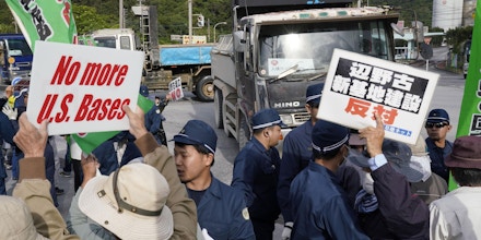 People stage a protest in Nago, Okinawa Prefecture, on Dec. 3, 2019, against the planned base relocation of a key U.S. military base to the city's coastal area of Henoko from another part of the southern Japan prefecture. Full-fledged landfill work started in December 2018 and continues at the relocation site. (Kyodo via AP Images) ==Kyodo