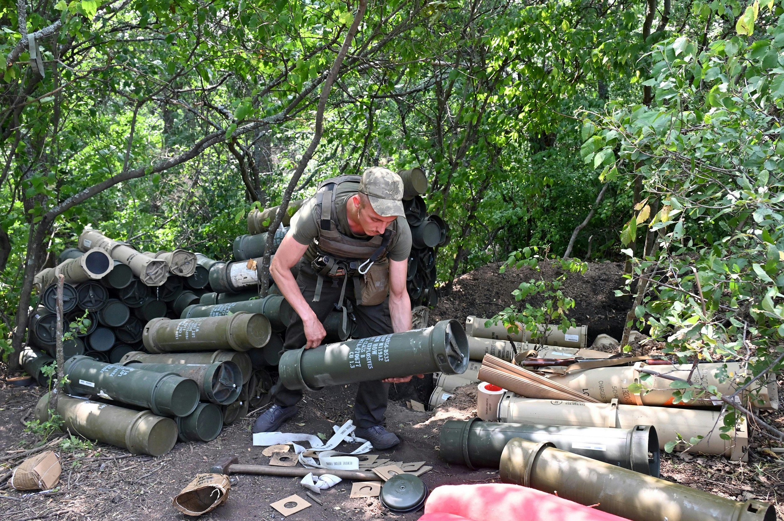 Ukrainian gunmen prepares powder charges for US made M777 howitzers prior to loading their gun on the front line in the Kharkiv region on August 1, 2022.