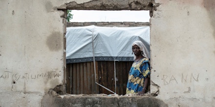 A woman looks through a window in the Rann Internally-Displaced Peoples (IDP) camp in northeastern Nigeria near the Cameroonian border on July 29, 2017.On January 17, 2017 the Rann Internally-Displaced Persons (IDP) camp was bombed by the Nigerian Air Force (NAF), injuring hundreds of people, killing dozens of civilians and at least six humanitarian workers, in the mistaken belief that the large congregation of people was a Boko Haram militant gathering. / AFP PHOTO / STEFAN HEUNIS (Photo credit should read STEFAN HEUNIS/AFP via Getty Images)