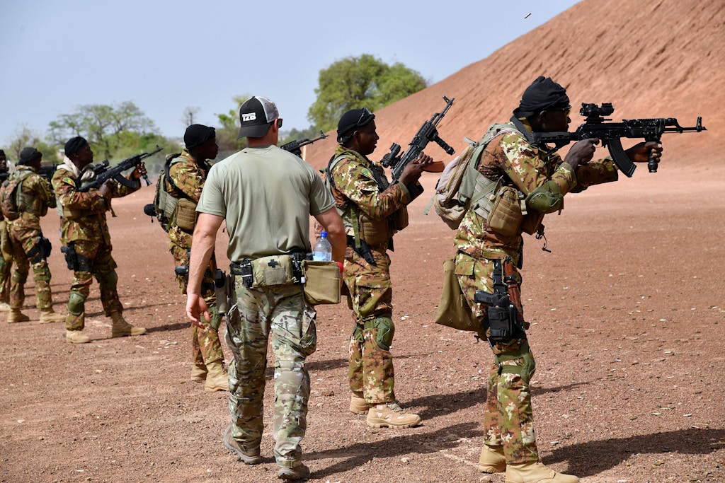 A US army instructor walks next to Malian soldiers during an anti-terrorism exercise at the Kamboinse - General Bila Zagre military camp on April 12, 2018 near Ouagadougo in Burkina Faso.