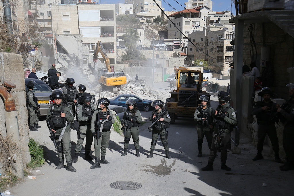 Israeli forces take security measures around the site as demolition works carried out by Israeli forces in Isawiya district of Eastern Jerusalem on December 24, 2019. A building, which is under construction, belongs to a Palestinian demolished by Israeli forces for allegedly being unauthorized. (Photo by Mostafa Alkharouf/Anadolu Agency via Getty Images)