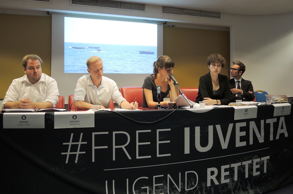 Representatives of the German relief organisation 'Jugend Rettet' (lit. youth rescues) speaks during a press conference in Trapani, Italy, 19 September 2017. After a court hearing the representatives take position on the allegations of having worked together with traffickers in the Mediterranean Sea. Lawyer Leonardo Marino can be seen on the right. Photo: Lena Klimkeit/dpa (Photo by Lena Klimkeit/picture alliance via Getty Images)