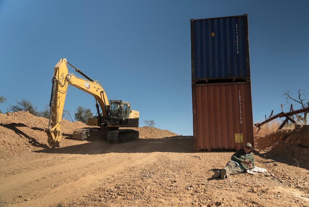Andrew Kayner, 71, sits down and blocks construction of Governor Ducey’s shipping container wall on the US-Mexico border in the Coronado National Forest in Arizona on November 29th, 2022.