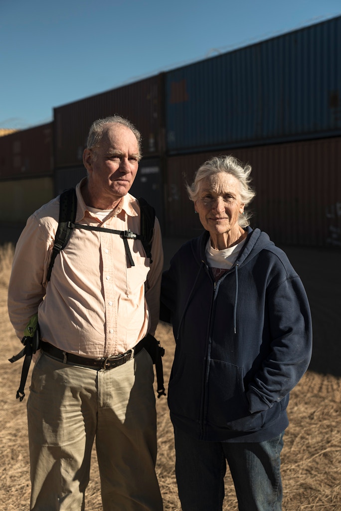 Portrait of Michael and Christie Brown near the shipping container wall on the U.S.-Mexico border in the Coronado National Forest in Arizona on November 29th, 2022.