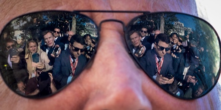 Reporters are reflected in the sunglasses of President Joe Biden as he speaks to the press at the White House in Washington, D.C., on Oct. 6, 2022.


