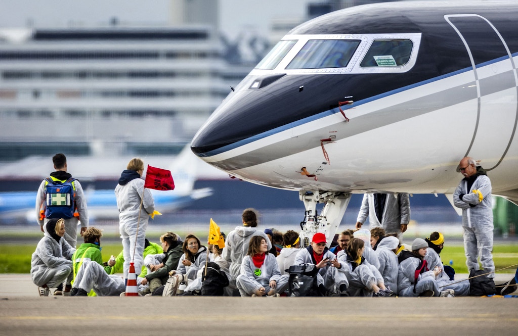 Milieudefensie, Extinction Rebellion, Greenpeace and other organisations members sit in front of an aircraft during a protest at Schiphol Airport, Amsterdam, Nov. 5, 2022.