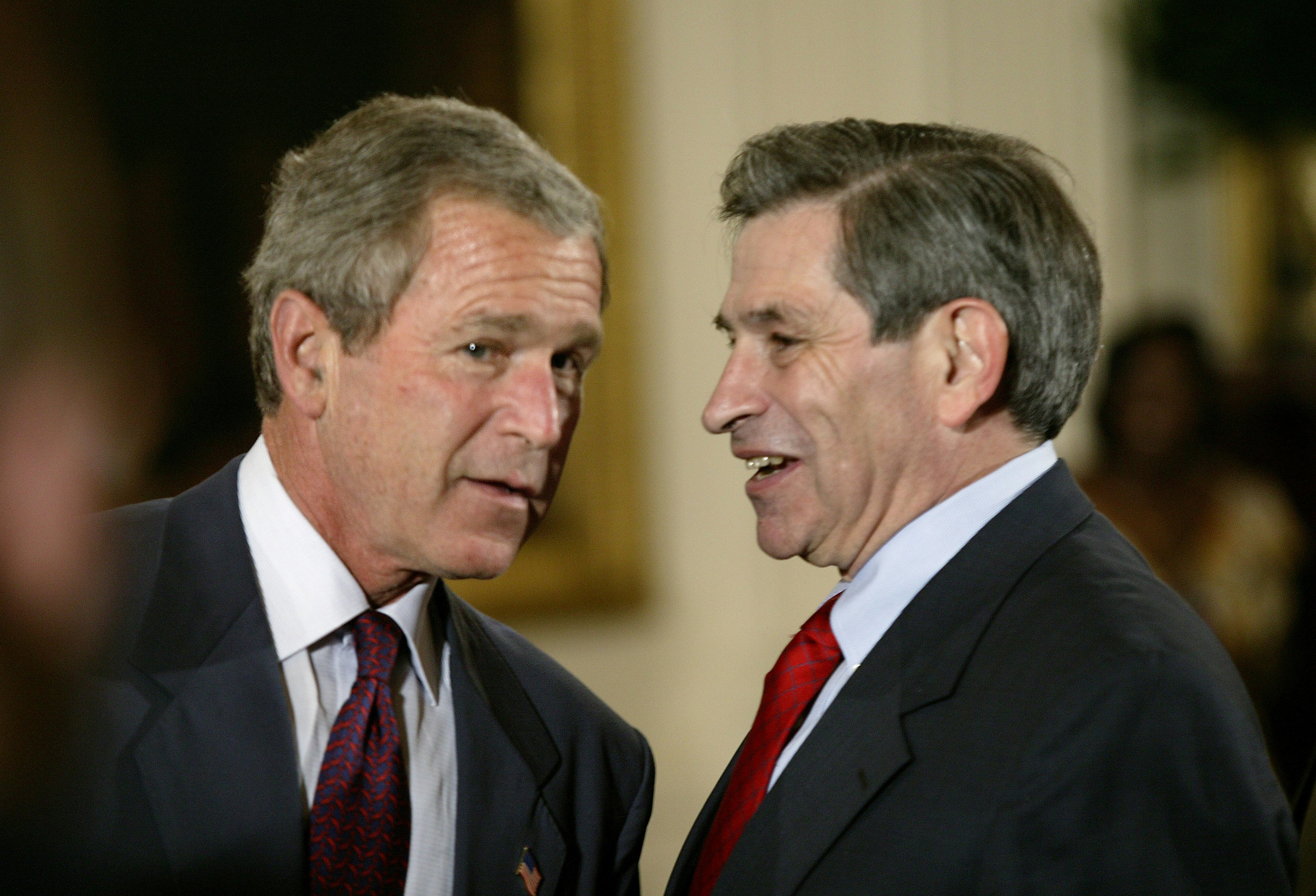 United States President George W. Bush talks to Deputy Secretary of Defense Paul Wolfowitz after thanking American servicemen and women for re-enlisting in the armed forces at a ceremony in the East Room of the White House. As a new poll showed American confidence slipping over the U.S.-role in post-war Iraq, Bush vowed to defeat those attacking coalition forces. (Photo by Brooks Kraft LLC/Corbis via Getty Images)